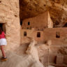 SWs015h: Visitor takes a closer look in side Spruce Tree House ruin at Mesa Verde National Park. Photo by Tom Stillo/CTO